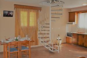 a kitchen and dining room with a spiral staircase in a room at MARIANNA in Sidari