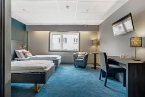 a hotel room with two beds and a desk at Hotel Haugesund in Haugesund