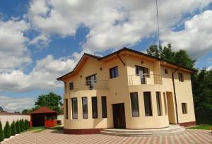 a large house with a balcony on top of it at Vila NICHOLAS in Bărcăneşti