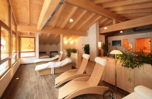 una sala de estar con muebles blancos y techos de madera. en Hotel UNTERKRÄMERHOF en Fusch an der Glocknerstraße