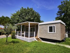 een tiny house met een veranda in een tuin bij The Garda Village in Sirmione