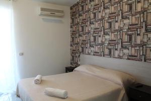 a bedroom with a bed and a wall with a picture at VesuView Guest House near the Ruins in Pompei