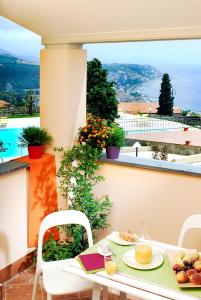 a table with a plate of food on a balcony at Residence Villa Beuca in Cogoleto