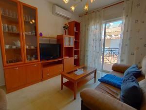 a living room with a couch and a tv at Bonito Apartamento Vacacional in Motril