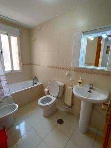 a bathroom with a toilet and a sink and a tub at Bonito Apartamento Vacacional in Motril