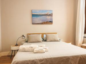 a bedroom with a bed with towels on it at Apodaca Rooms in Cádiz
