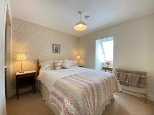 a bedroom with a bed with a pink and white blanket at St Margaret's Cottage, Edinburgh in Edinburgh