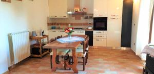 a kitchen with a table with a vase of flowers on it at Casina di Pacina in Abbadia di Montepulciano +18 photos