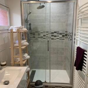 a shower with a glass door in a bathroom at Private house with a view on Bayeux's Cathedrale in Bayeux