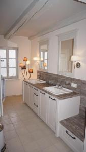 een witte keuken met een wastafel en een spiegel bij Altstadtperle Wernigerode in Wernigerode