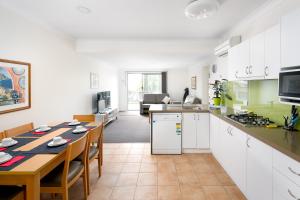 a kitchen and dining room with a table and a kitchen and a living room at Bayview Apartments by Classic Holidays in Cowes