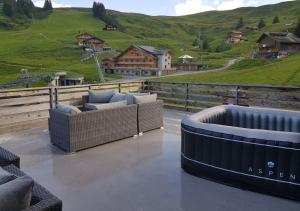 a patio with couches and a view of a mountain at Hôtel des Portes du Soleil in Les Crosets