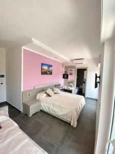 sypialnia z dużym łóżkiem i różową ścianą w obiekcie Bellavista Formia w mieście Formia