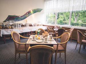 - une salle à manger avec des tables, des chaises et des fenêtres dans l'établissement Rheinhotel Starkenburger Hof, à Bingen am Rhein