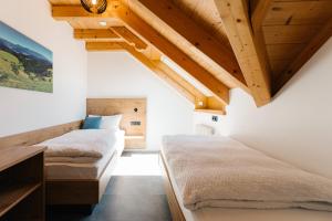 - 2 lits dans une chambre dotée de plafonds en bois dans l'établissement Moderne 3 Zi.-FeWo BlackForestArt Nähe Freiburg, à Simonswald