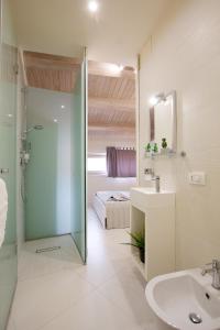 a bathroom with a shower and a sink and a bed at Stesicoro Exclusive House in Catania +169 photos