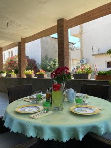 uma mesa com pratos e um vaso de flores em Apartments Toni em Ulcinj
