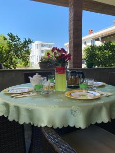 uma mesa branca com pratos e copos numa varanda em Apartments Toni em Ulcinj