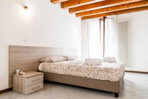 una camera da letto con un letto e due asciugamani di INTERO APPARTAMENTO nel cuore di VICENZA a Vicenza