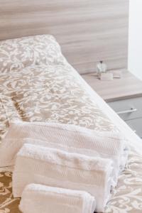 un letto bianco con due asciugamani sopra di INTERO APPARTAMENTO nel cuore di VICENZA a Vicenza
