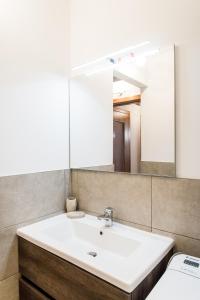 bagno con lavandino bianco e specchio di INTERO APPARTAMENTO nel cuore di VICENZA a Vicenza