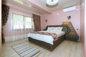 una camera rosa con un grande letto di Vila Cataleya 2 a Venus