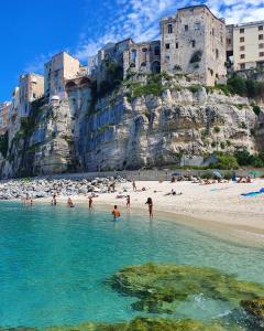 grupa ludzi w wodzie na plaży w obiekcie Domus Centro Tropea w Tropei