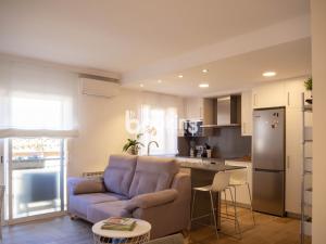 sala de estar con sofá y cocina en Indústria Apartament per 3 persones a 2 minuts de la platja amb Aire acondicionat i plaça d'aparcament, en Sant Feliu de Guíxols