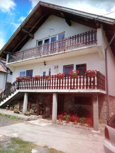 una casa con un balcón con flores. en APARTMAN PAVELIĆ, en Lovinac