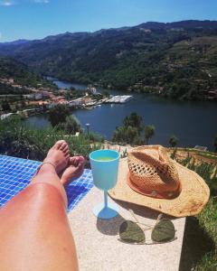 a person with their feet up on a table with a drink at Casa de Ribadouro in Baião
