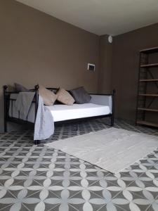 a bedroom with a white bed with a rug at Al biancospino- Camere- Ristorante in Bossolasco
