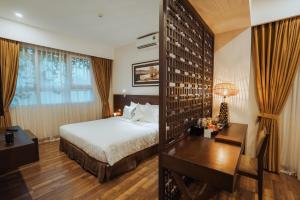 a hotel room with a bed and a desk and a desk at Thang Long Opera Hotel in Hanoi