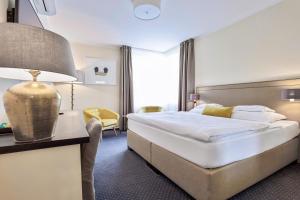 a hotel room with a large bed and a lamp at Mamma´s Boutique Hotel in Poděbrady