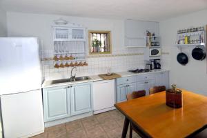 a kitchen with white cabinets and a wooden table at Mirador La Sorrueda in La Sorrueda