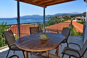 a wooden table with a hat sitting on a balcony at Antonias house in Stoupa