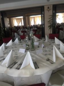 een tafel met witte servetten en zilverwerk erop bij Hotel Condor in Mamaia