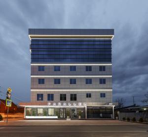 um edifício com uma placa na frente dele em Parallel Hotel & Conference Krasnodar em Krasnodar