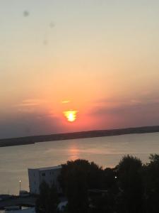 einen Sonnenuntergang über dem Wasser mit der Sonne am Himmel in der Unterkunft Hotel Condor in Mamaia