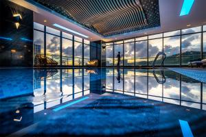 una piscina en un edificio con una persona caminando en el agua en DeLaSea Ha Long Hotel, en Ha Long