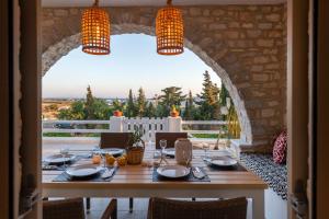 a dining room with a table and a large window at Villa Giorgianna -near Aliki beach with pool in Aliki