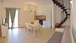 a kitchen and dining room with a table and chairs at Le Villette di Capo Testa in Santa Teresa Gallura