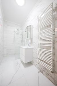 Baño blanco con lavabo y espejo en Hotel Lucija en Posedarje