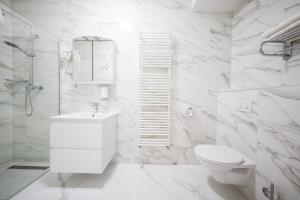 uma casa de banho branca com um WC e um chuveiro em Hotel Lucija em Posedarje