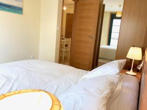 ein weißes Bett in einem Zimmer mit einem Schlafzimmer in der Unterkunft The Cliffs - Espasante Nook in O Porto de Espasante