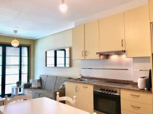 eine Küche und ein Wohnzimmer mit einem Sofa und einem Tisch in der Unterkunft The Cliffs - Espasante Nook in O Porto de Espasante