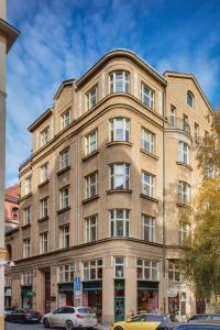 un grand bâtiment avec des voitures garées devant lui dans l'établissement Templova 6 Old Town Apartment, à Prague