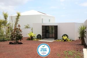 蓬塔德尔加达Belém Lodge的一座白色的房子，前面有一块牌子