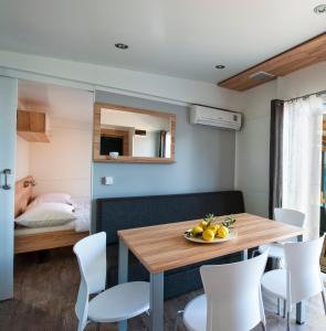 jadalnia ze stołem, krzesłami i łóżkiem w obiekcie Adria Village Superior Mobile Homes w Pakoštane +10 zdjęć