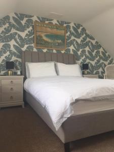 1 dormitorio con 1 cama y una pintura en la pared en The Alendale Guesthouse en Weymouth