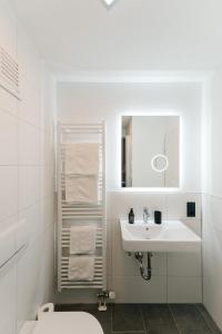 a white bathroom with a sink and a toilet at Modernes Appartment BlackForest Art 35 qm Nähe Freiburg in Simonswald